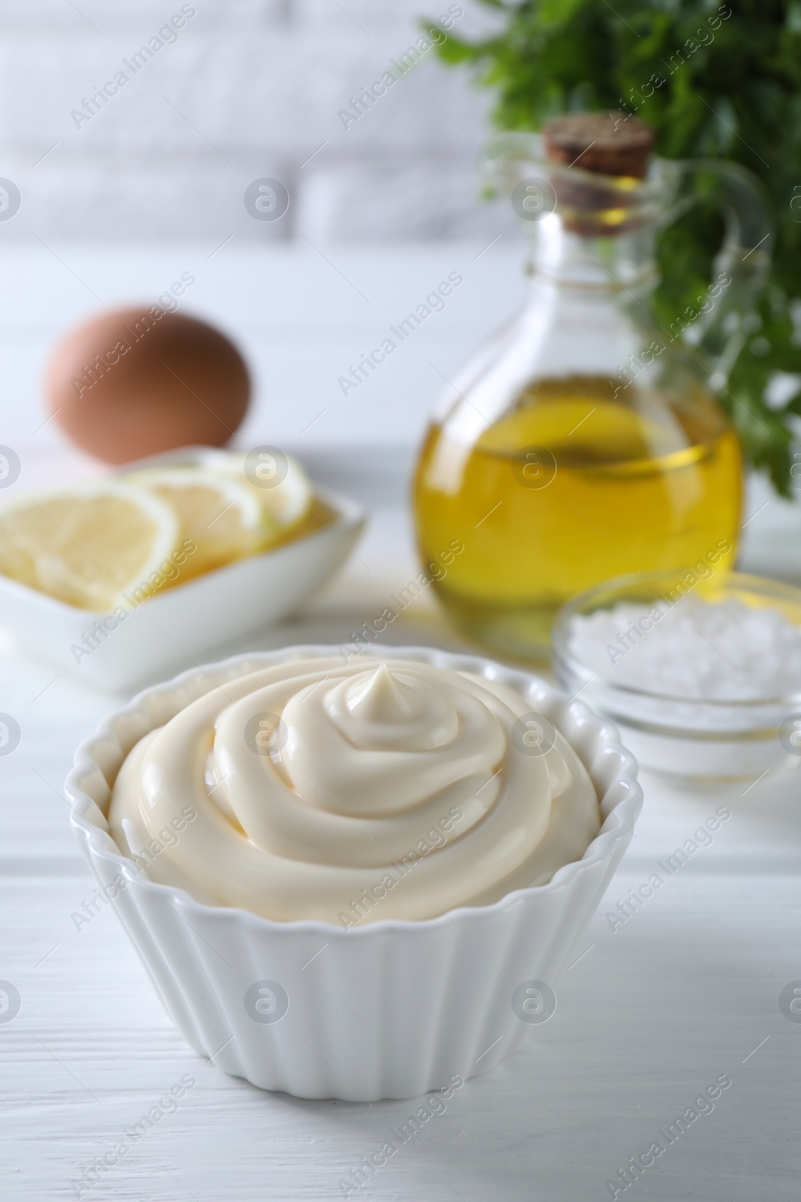 Photo of Fresh mayonnaise sauce in bowl on white wooden table