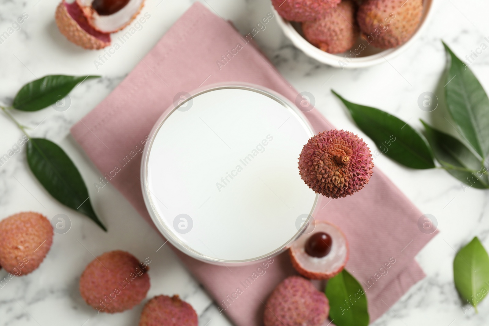 Photo of Fresh lychee juice and fruits on white marble table, flat lay