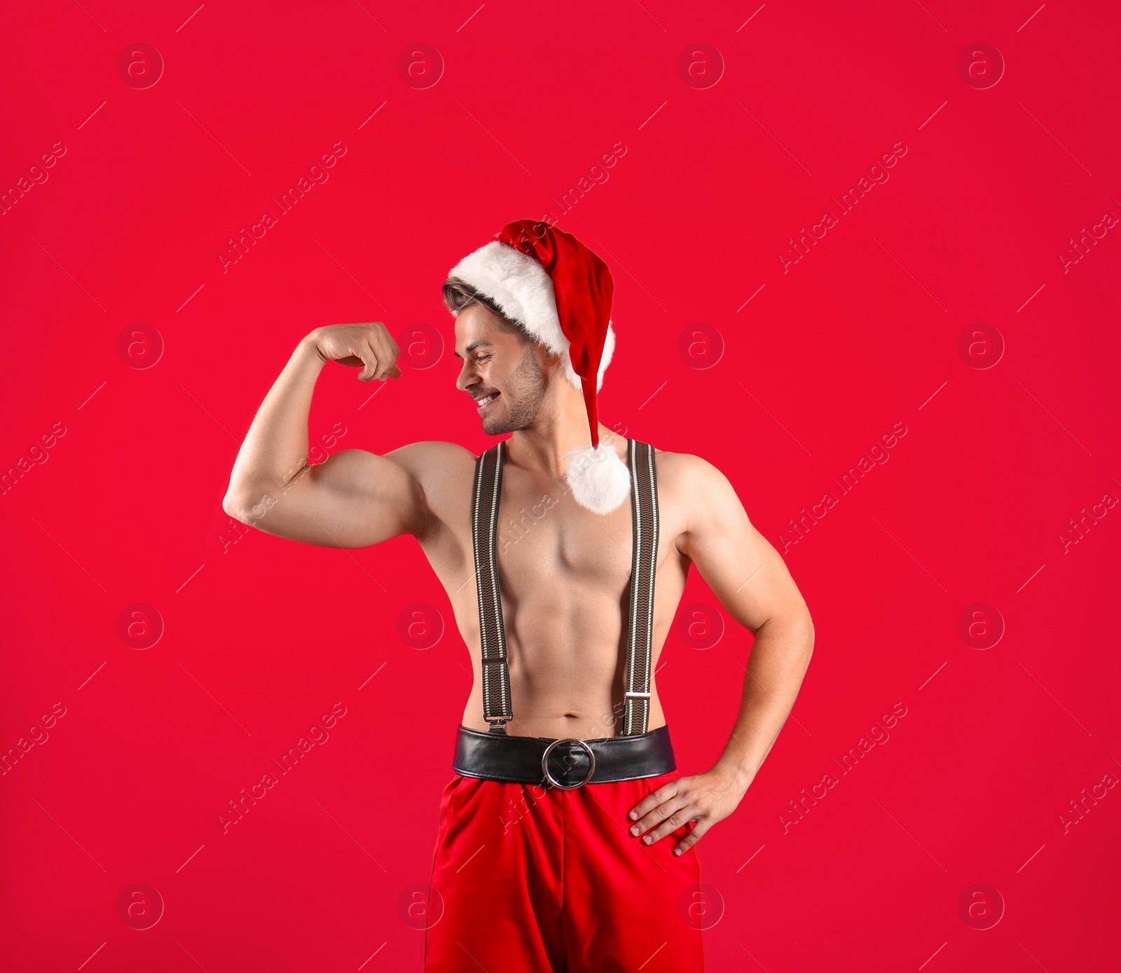 Photo of Shirtless young Santa Claus with sexy body on color background