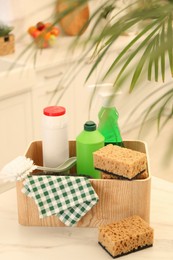 Different cleaning supplies on table in kitchen