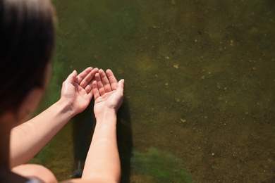 Photo of Woman taking pure water from river, closeup. Nature healing power