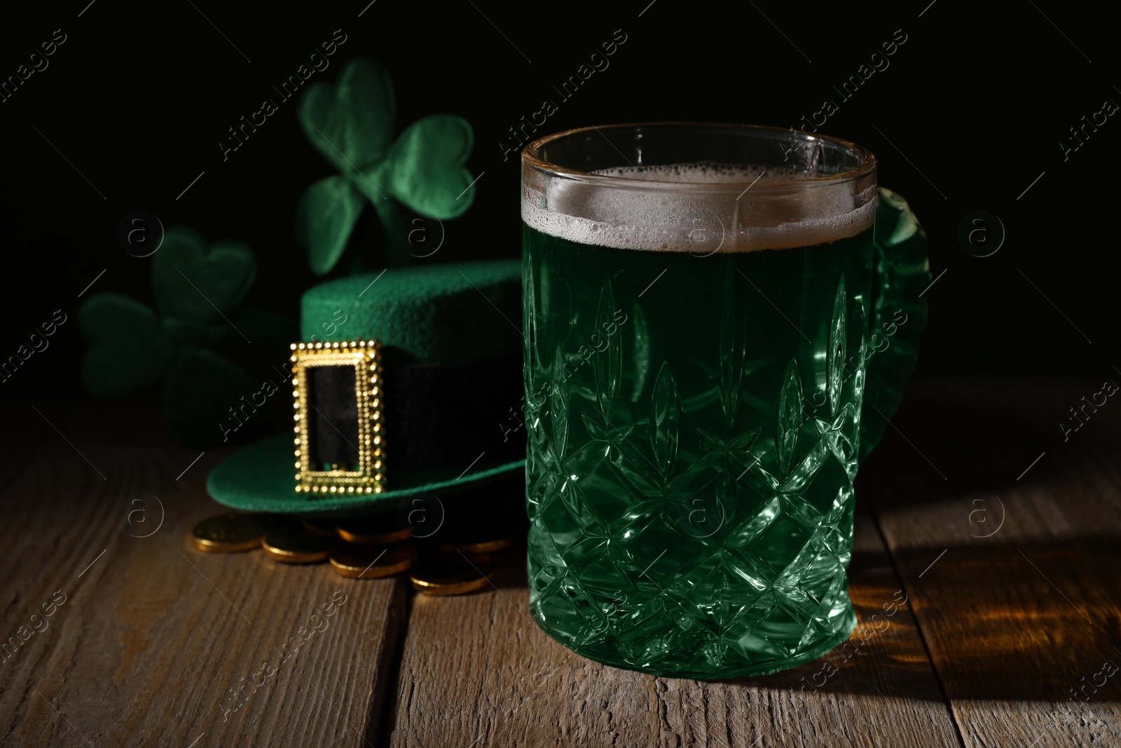 Photo of St. Patrick's day party. Green beer, leprechaun hat, gold and decorative clover leaves on wooden table