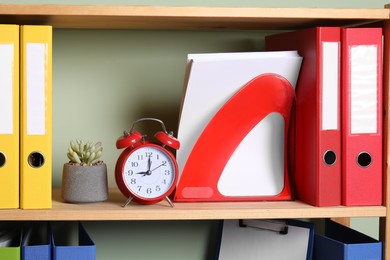 Colorful binder office folders and other stationery on shelving unit