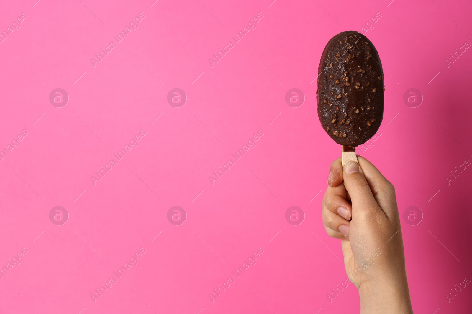 Photo of Woman holding delicious ice cream with chocolate against color background, space for text