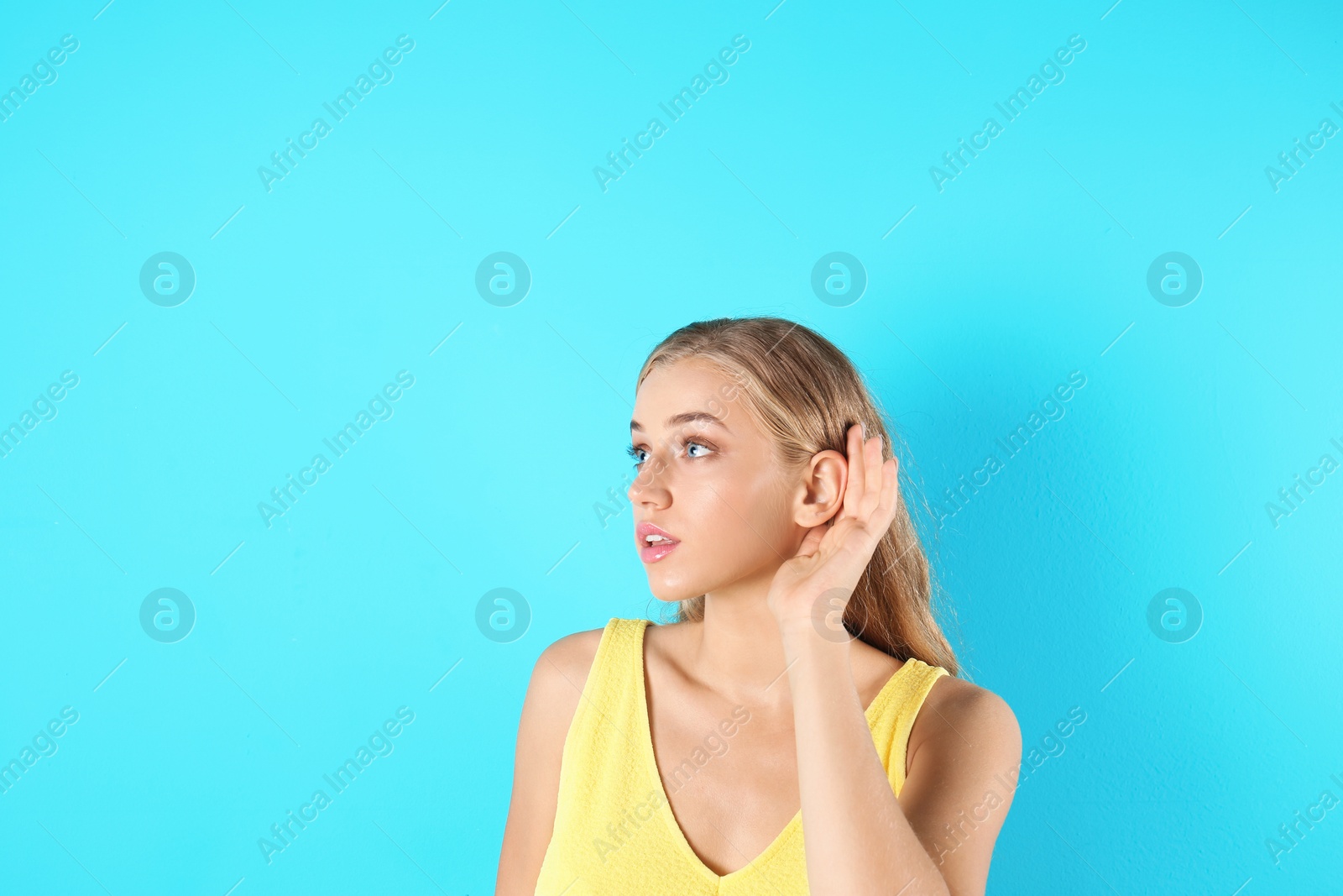 Photo of Young woman with hearing problem on color background