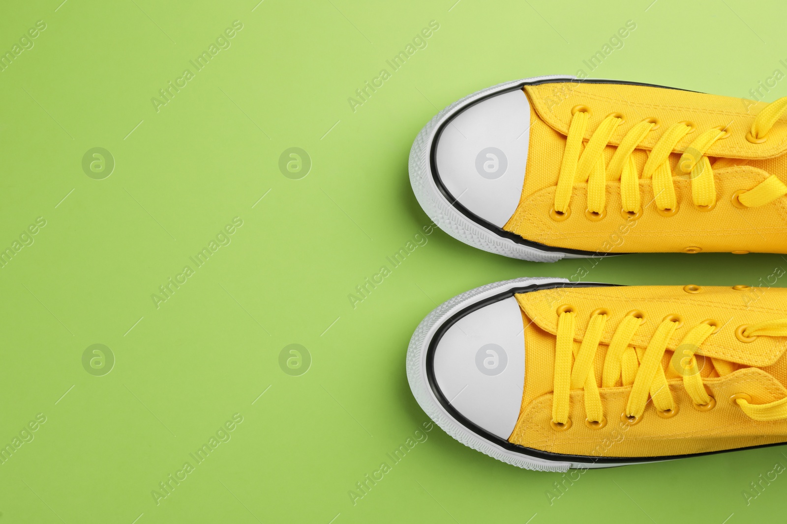 Photo of Pair of trendy sneakers on green background, flat lay. Space for text