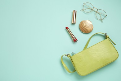 Flat lay composition with stylish baguette handbag on light blue background. Space for text