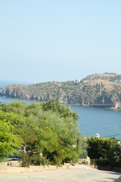 Photo of Beautiful view of pathway leading to sea and coastal city on sunny day