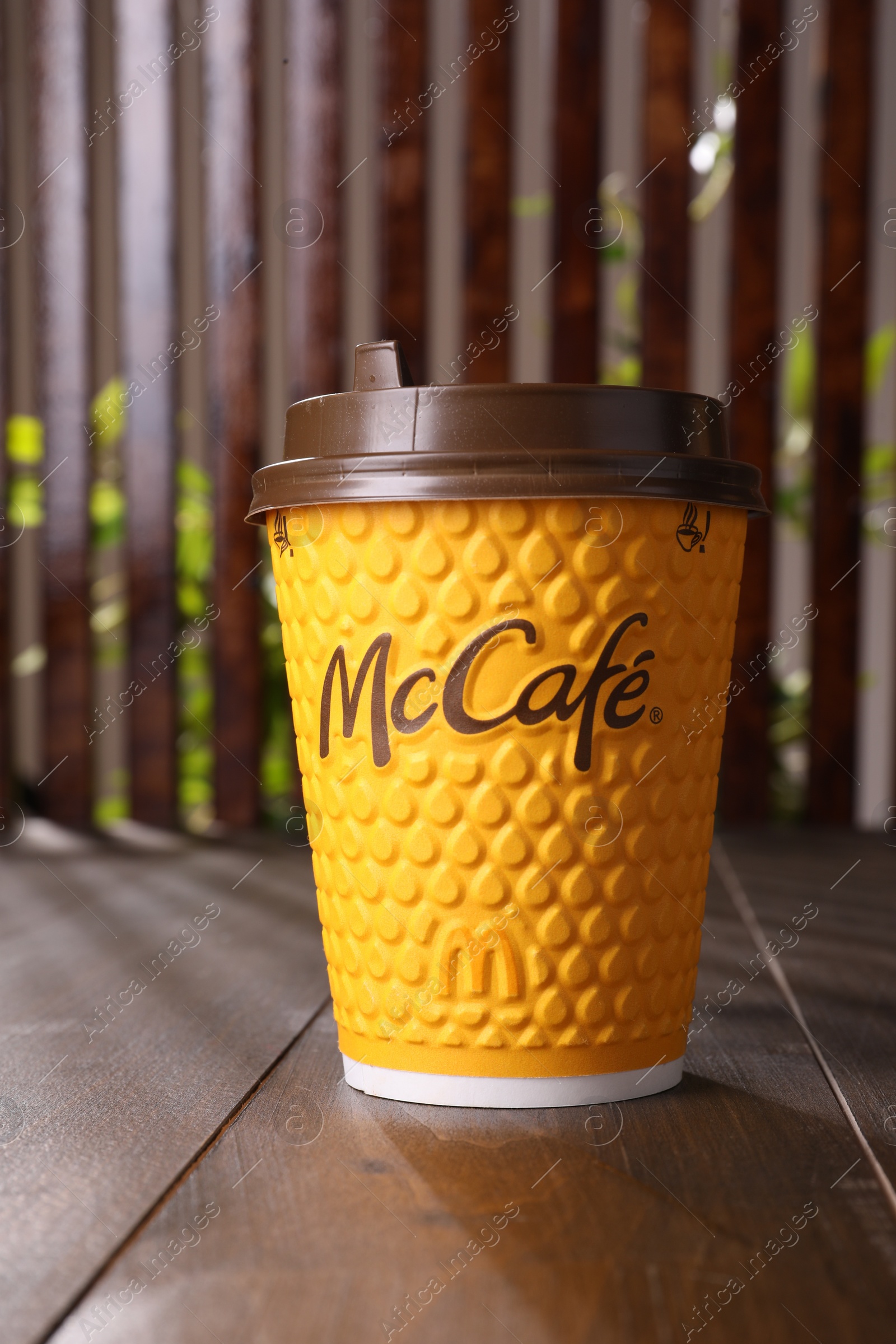 Photo of MYKOLAIV, UKRAINE - AUGUST 12, 2021: Hot McDonald's drink on wooden table