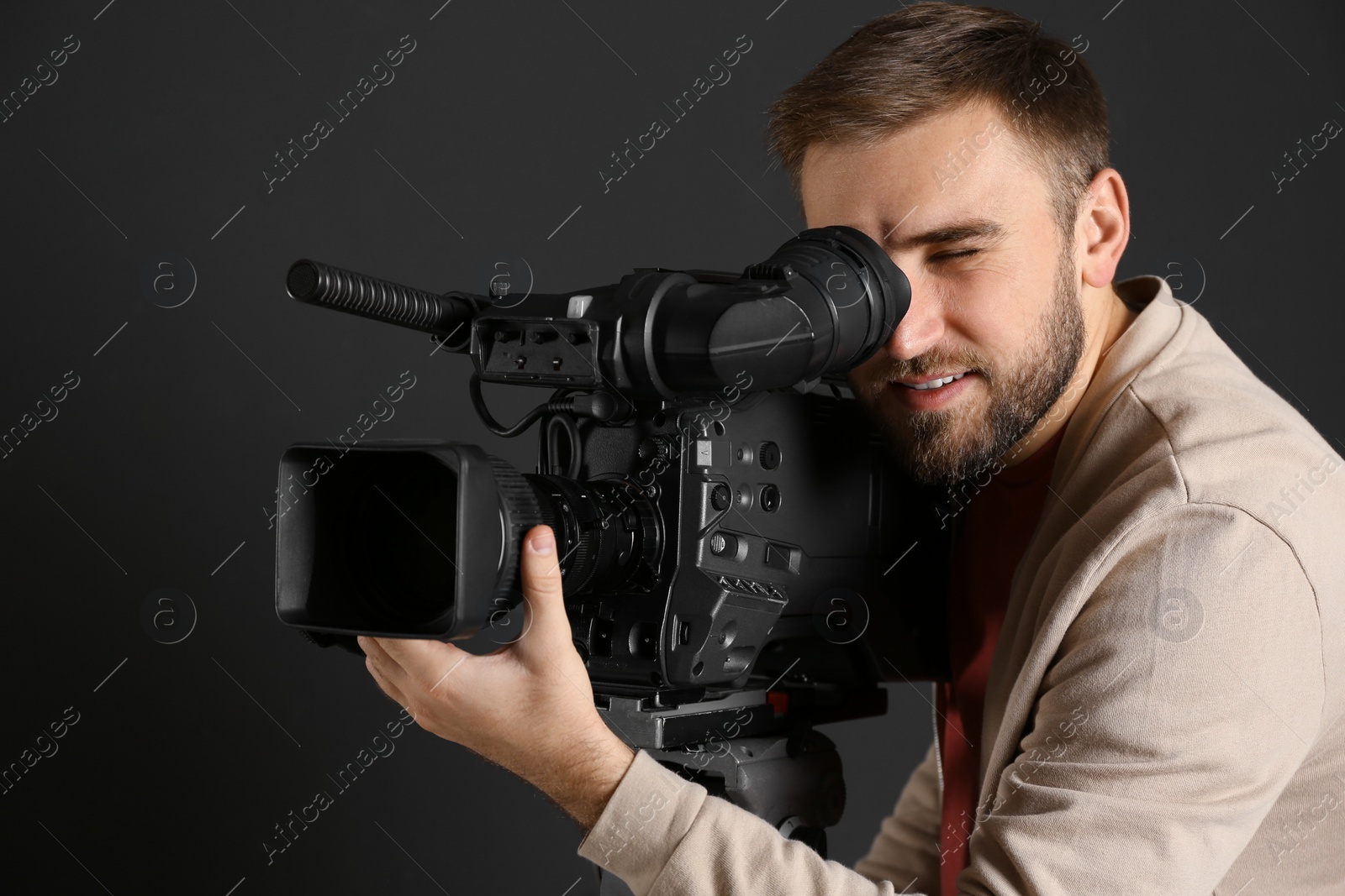 Photo of Operator with professional video camera on black background