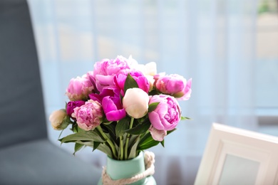 Photo of Vase with bouquet of beautiful peonies in room