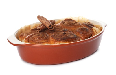 Baking dish with cinnamon rolls on white background