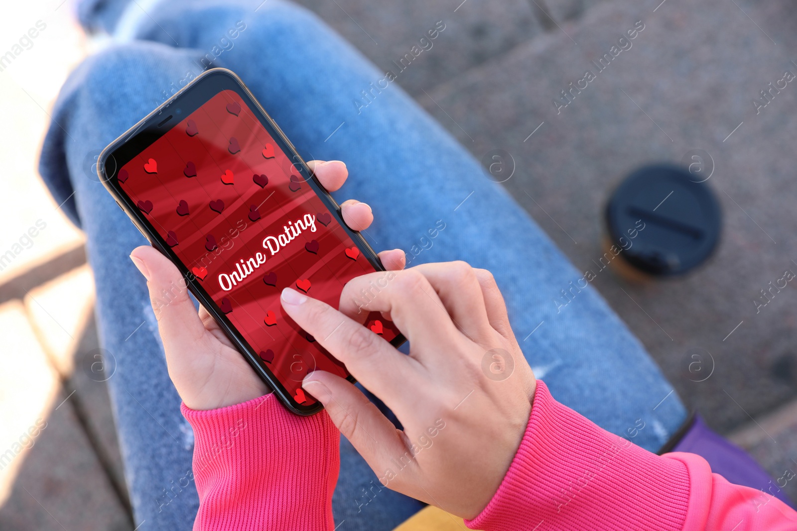 Image of Woman visiting dating site via smartphone outdoors, closeup