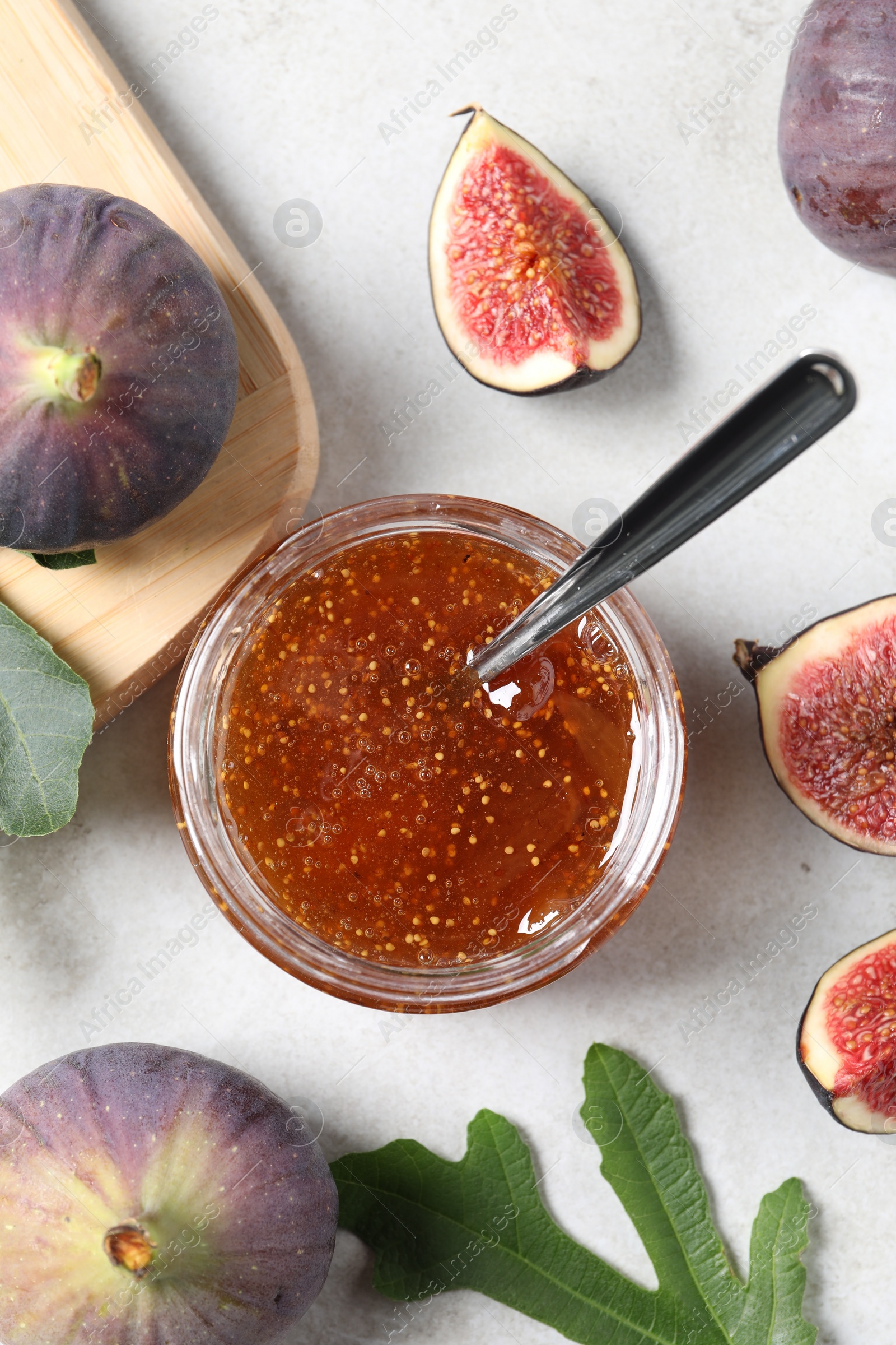 Photo of Jar with tasty sweet jam and fresh figs on white table, flat lay