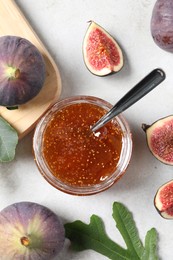 Photo of Jar with tasty sweet jam and fresh figs on white table, flat lay