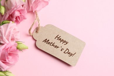 Happy Mother's Day greeting label and beautiful flowers on pink background