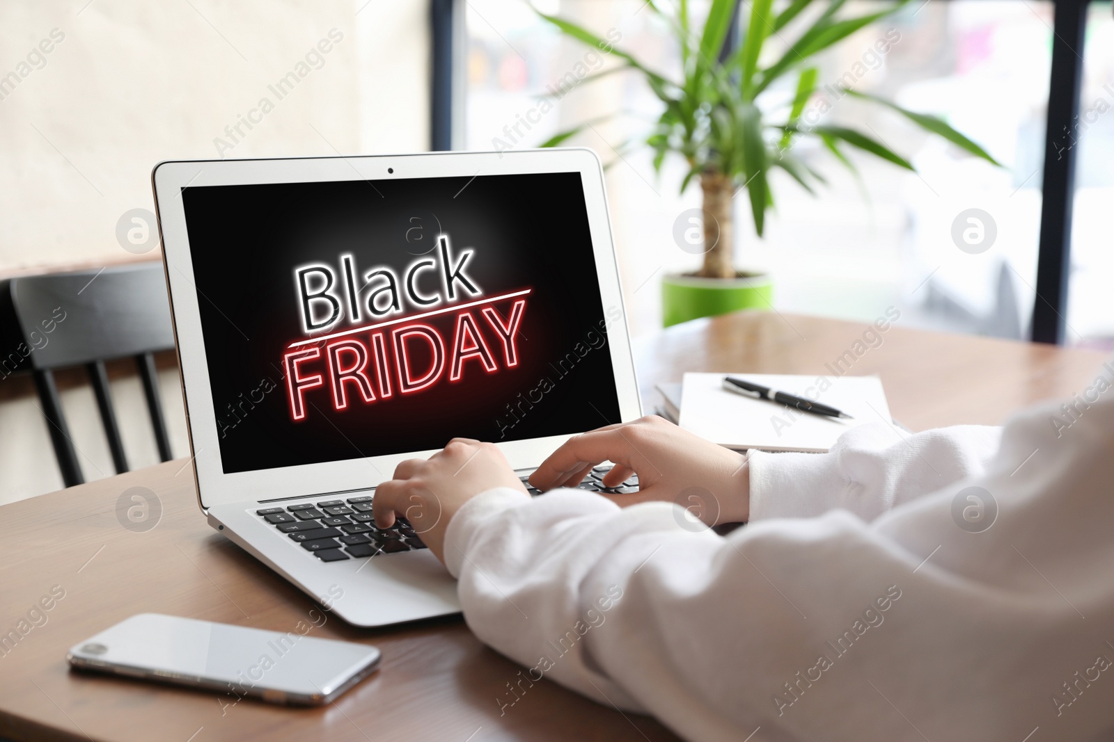 Image of Black Friday. Woman shopping online using laptop at table, closeup