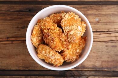 Photo of Bucket with yummy nuggets on wooden table, top view