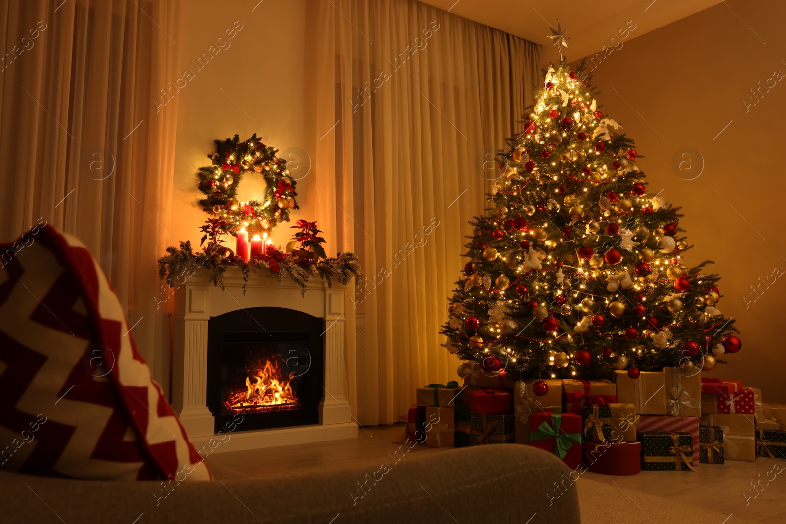 Photo of Beautiful Christmas tree and gifts near fireplace in festively decorated living room