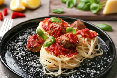 Photo of Delicious pasta with meatballs and tomato sauce on plate, closeup