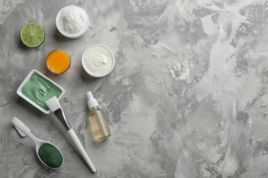 Flat lay composition with spirulina facial mask and ingredients on grey table. Space for text