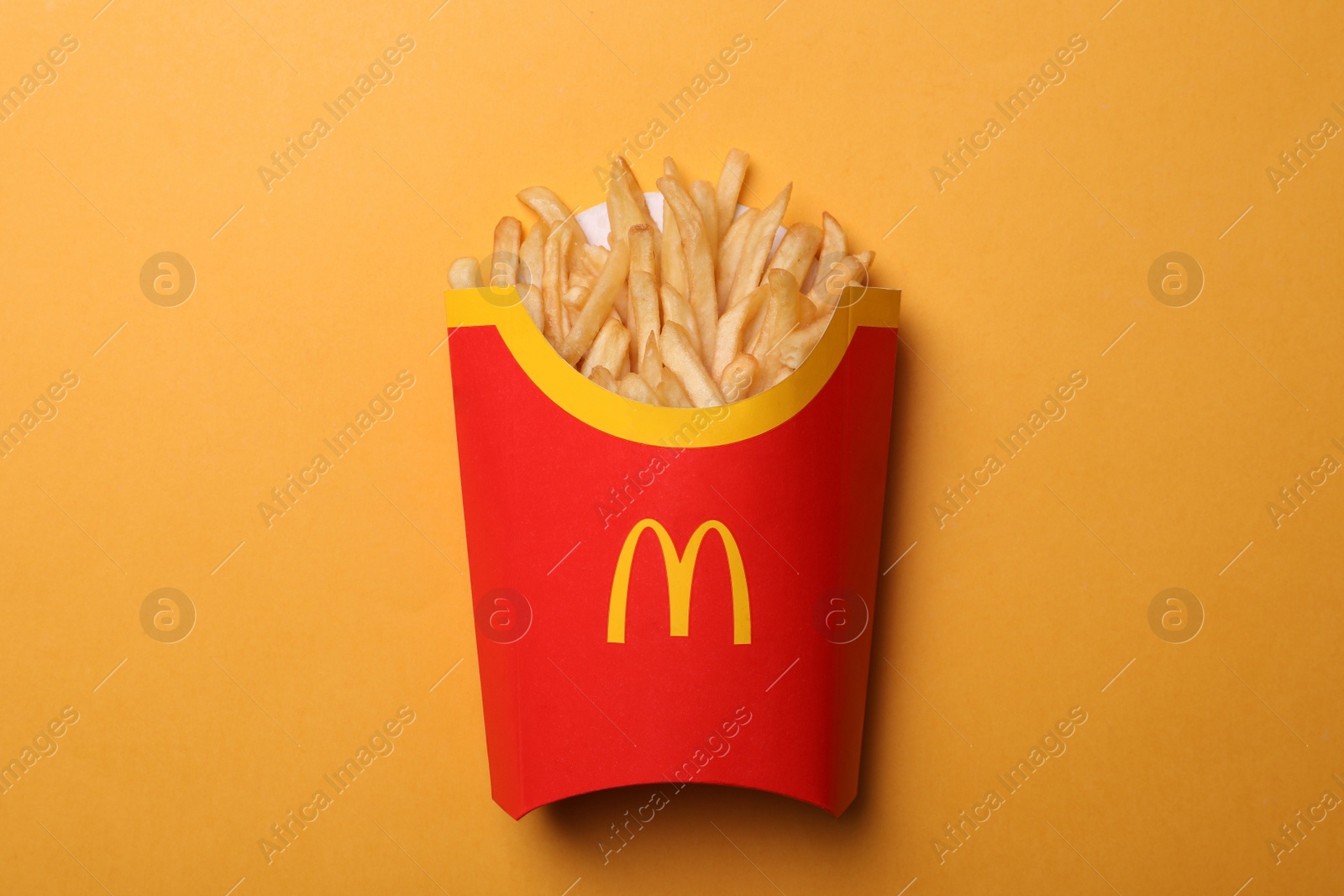 Photo of MYKOLAIV, UKRAINE - AUGUST 12, 2021: Big portion of McDonald's French fries on orange background, top view