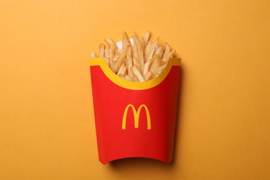Photo of MYKOLAIV, UKRAINE - AUGUST 12, 2021: Big portion of McDonald's French fries on orange background, top view