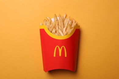 MYKOLAIV, UKRAINE - AUGUST 12, 2021: Big portion of McDonald's French fries on orange background, top view