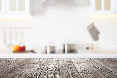 Empty wooden table and blurred view of stylish kitchen interior. Mockup for design