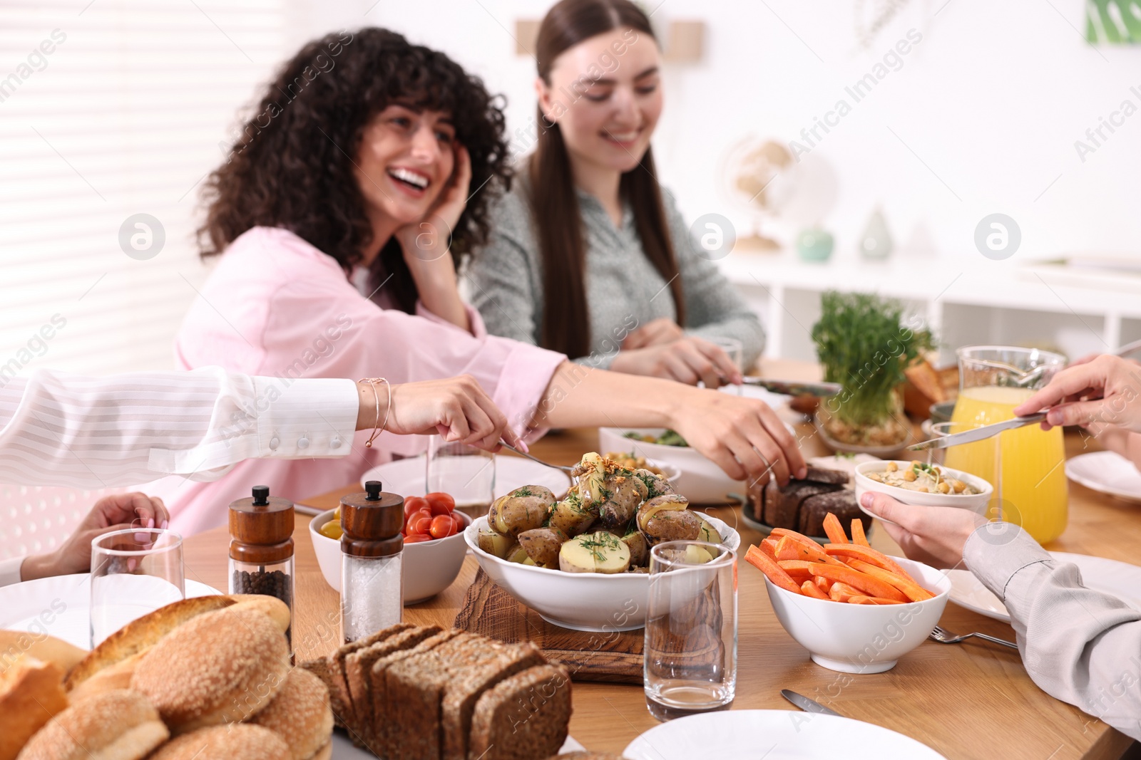 Photo of Friends eating vegetarian food at table indoors