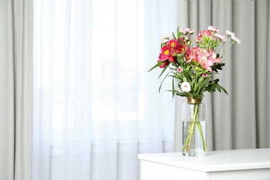 Vase with beautiful flowers on table near window indoors, space for text. Stylish element of interior design
