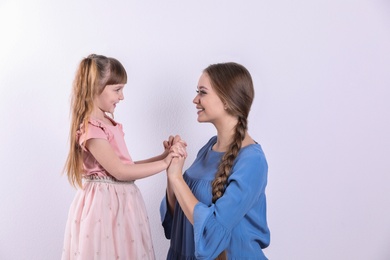 Happy woman and daughter in stylish clothes on white background