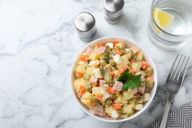 Delicious salad Olivier on marble table, flat lay. Space for text