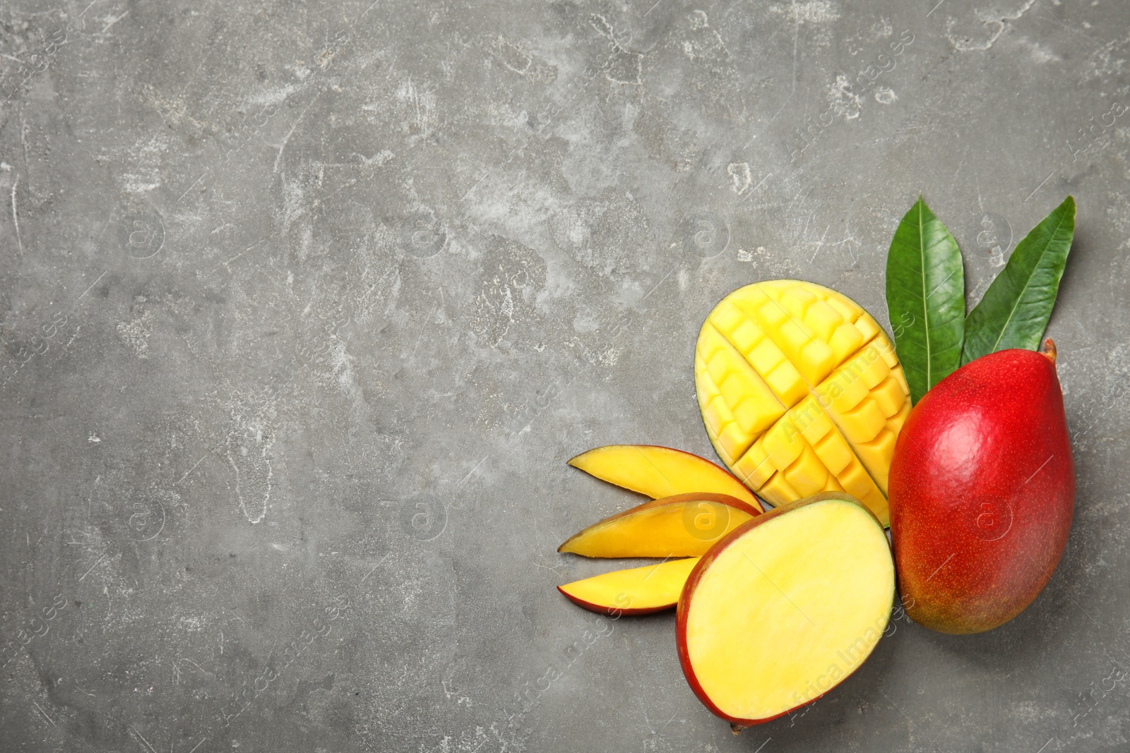 Photo of Flat lay composition with ripe mangoes and space for text on grey background