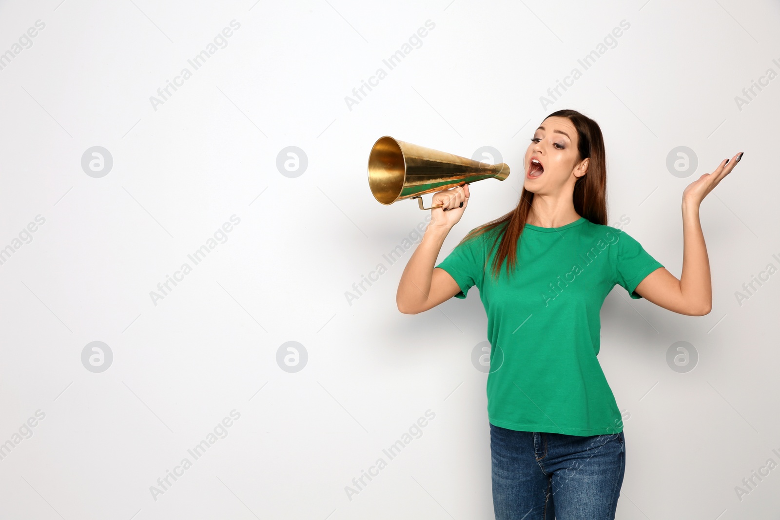 Photo of Young woman with megaphone on white background. Space for text