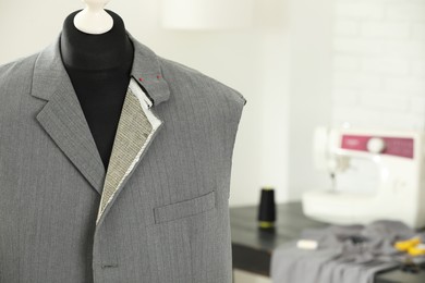 Mannequin with unfinished jacket in tailor shop, closeup. Space for text