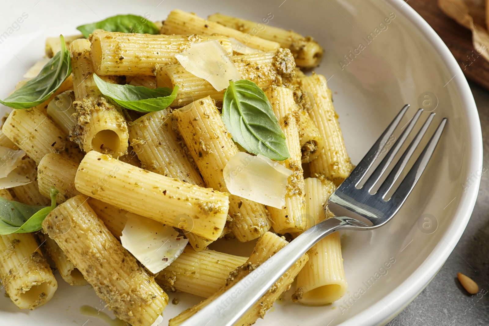 Photo of Delicious basil pesto pasta on plate, closeup