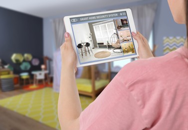 Image of Woman using smart home security system on tablet computer indoors, closeup. Device showing different rooms through cameras
