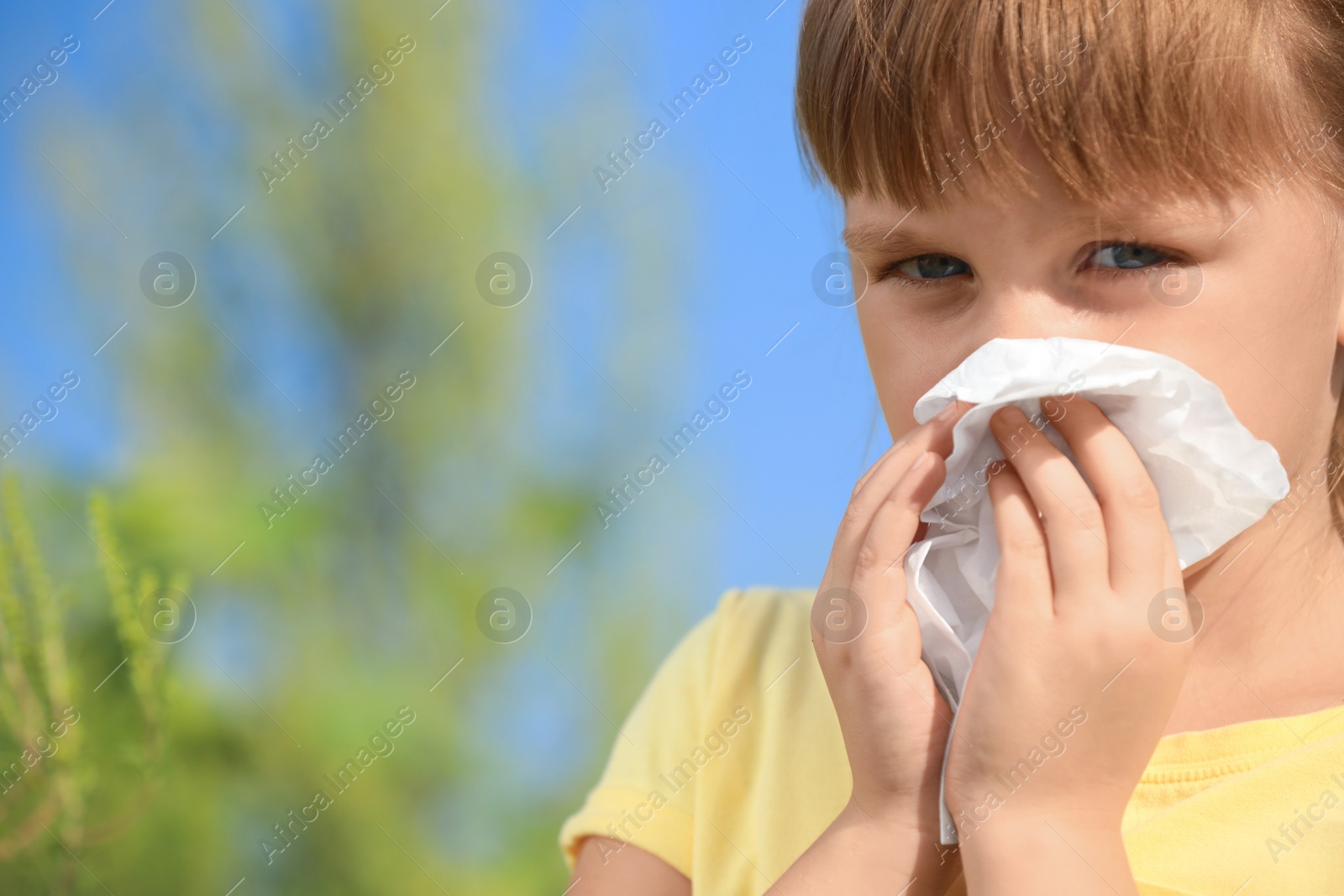 Photo of Little girl suffering from ragweed allergy outdoors, closeup