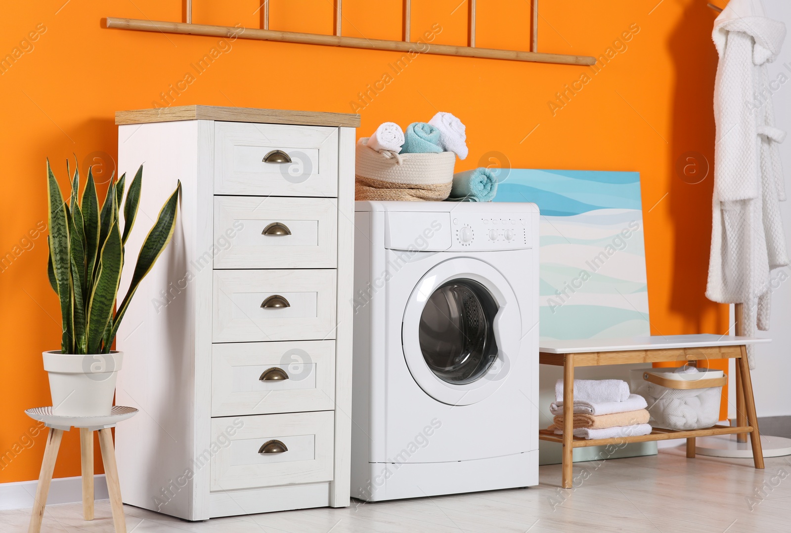 Photo of Stylish laundry room with washing machine. Interior design