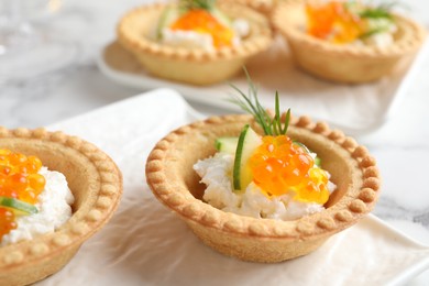 Delicious canapes with red caviar on table, closeup