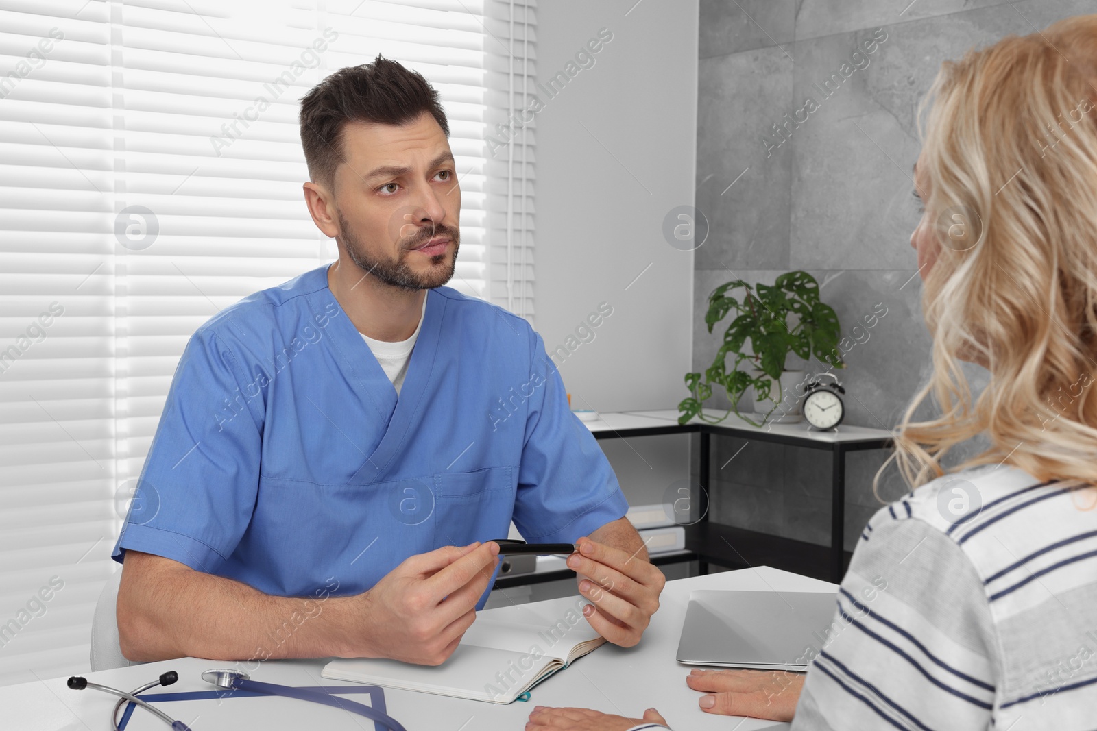 Photo of Doctor listening to patient's complaints during consultation in clinic