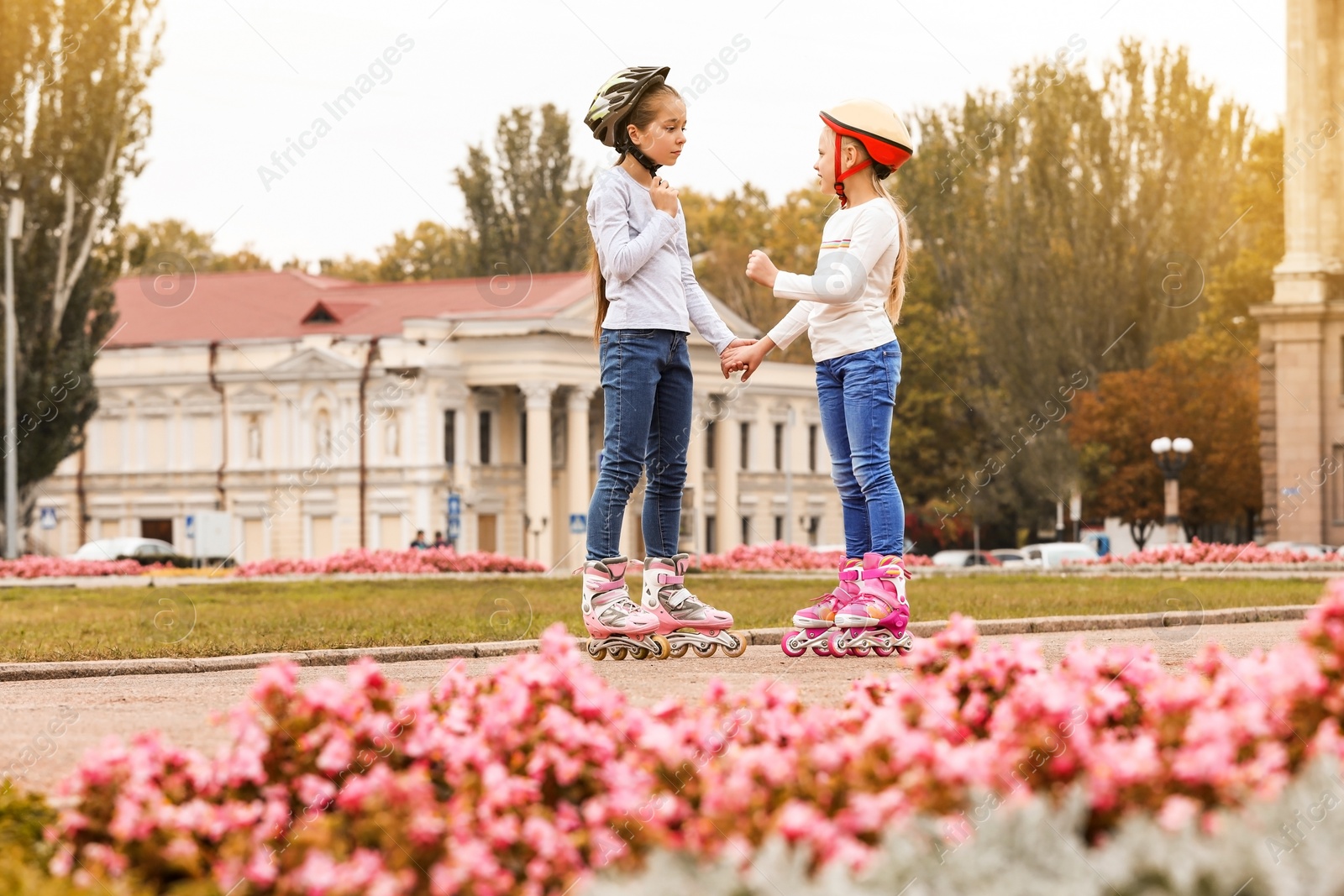 Photo of Happy children wearing roller skates on city street