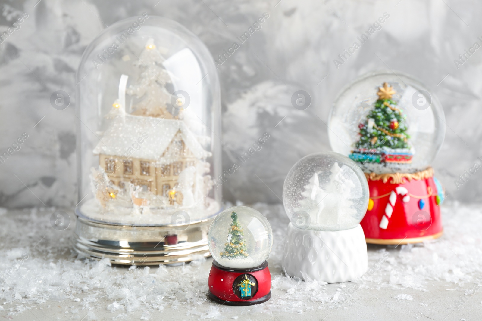 Photo of Set of different beautiful snow globes on table