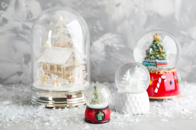 Photo of Set of different beautiful snow globes on table