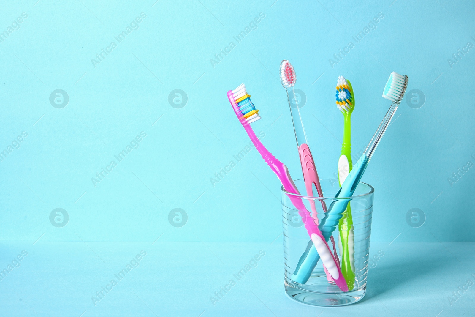 Photo of Cup with toothbrushes on color background. Dental care