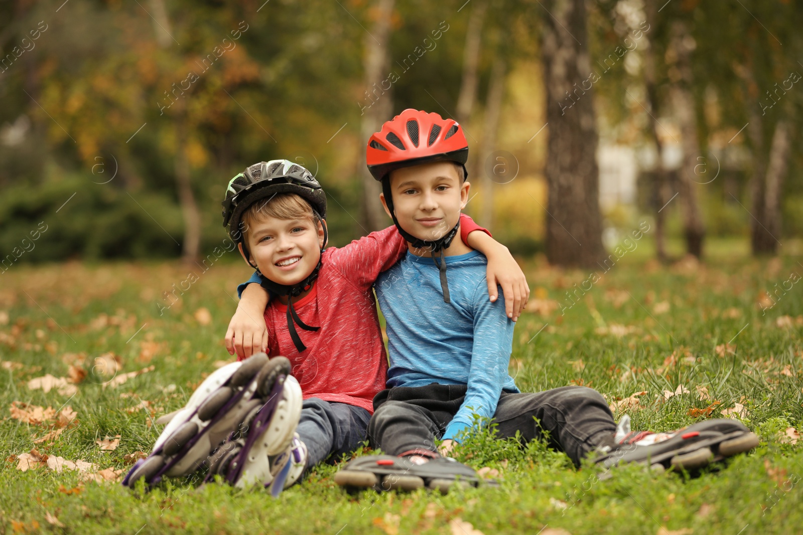 Photo of Cute roller skaters sitting on grass in park