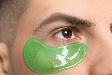 Photo of Man with green under eye patch, closeup
