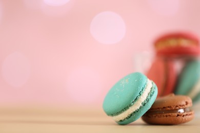 Photo of Delicious macarons on table against blurred background, closeup. Space for text