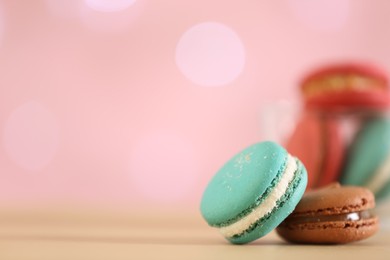 Delicious macarons on table against blurred background, closeup. Space for text